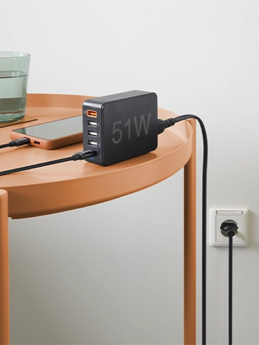 Smartphone lies on a table and charges via Hama quick charger 5 ports, 1x QC 3.0, 3x USB-A, 1x USB-C PD, 51 W