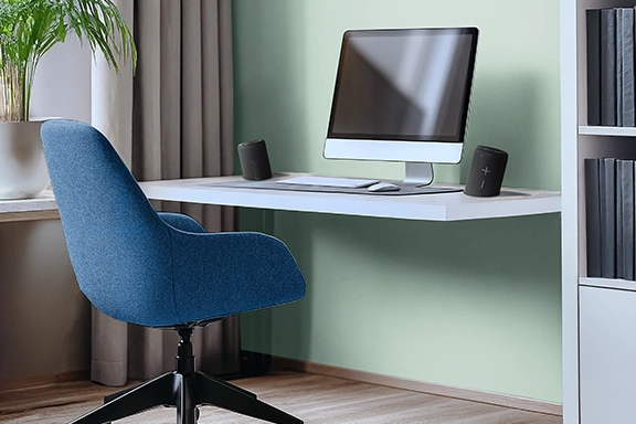 The true wireless stereo loudspeaker is placed on a desk, split to the left and right of the PC.