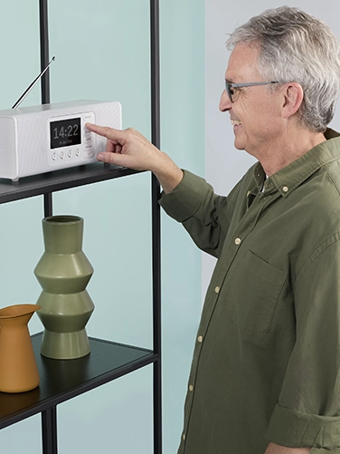 An elderly gentleman cheerfully operates the Hama digital radio "DR2002BT"